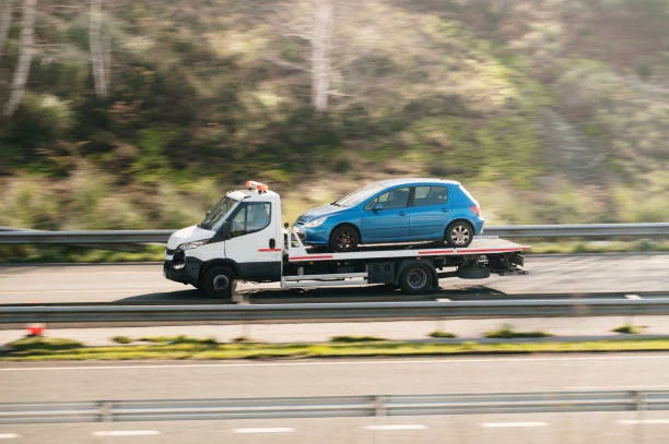 Carro attrezzi che trasporta un’auto su strada